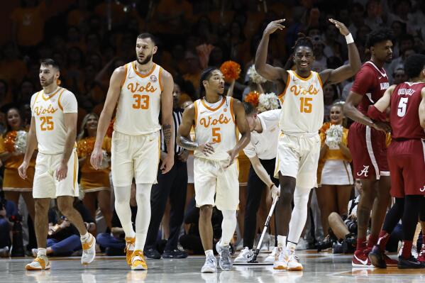 Tennessee guard Jahmai Mashack (15) encourages fans as he, guard Zakai Zeigler (5), forward Uros Plavsic (33), and guard Santiago Vescovi (25) take the court during the second half of an NCAA college basketball game against Alabama, Wednesday, Feb. 15, 2023, in Knoxville, Tenn. (AP Photo/Wade Payne)