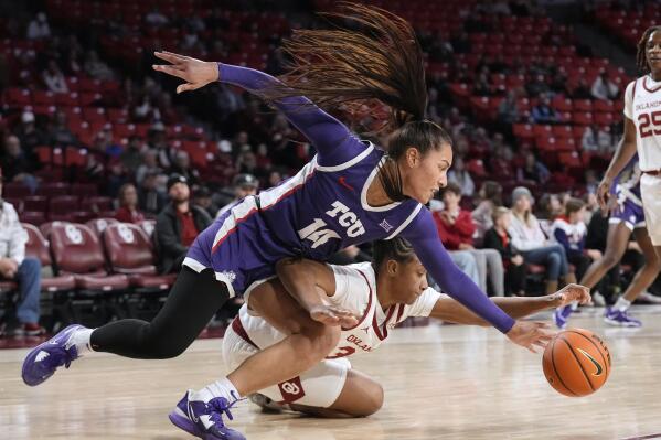 TCU forward Bella Cravens (14) and forward Liz Scott, right, reach for the ball in the first half of an NCAA college basketball game Tuesday, Jan. 31, 2023, in Norman, Okla. (AP Photo/Sue Ogrocki)
