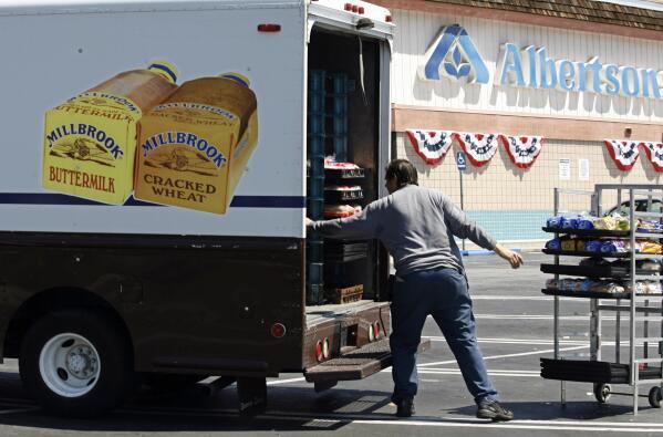 FILE - Mitch Maddox, a bread route salesman, loads bread Tuesday, May 30, 2006, outside the Eagle Rock Albertsons store in Los Angeles. Two of the nation’s largest grocers have agreed to merge in a deal that would help them better compete with Walmart, Amazon and other major companies that have stepped into the grocery business. Kroger on Friday, Oct. 14, 2022  bid $20 billion for Albertsons Companies Inc., or $34.10 per share. (AP Photo/Damian Dovarganes, File)