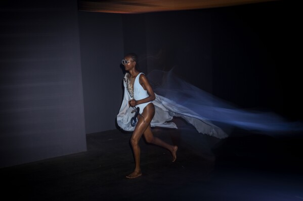 A model runs backstage during the fashion show of Spanish designer Claro Couture at the Mercedes-Benz Fashion Week in Madrid Spain, on Sept. 14, 2023. (AP Photo/Bernat Armangue)