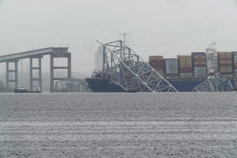 A container ship rests against the wreckage of the Francis Scott Key Bridge on Thursday, March 28, 2024, in Baltimore, Md. After days of searching through murky water for the workers missing after the bridge collapsed, officials are turning their attention Thursday to what promises to be a massive salvage operation. (AP Photo/Matt Rourke)