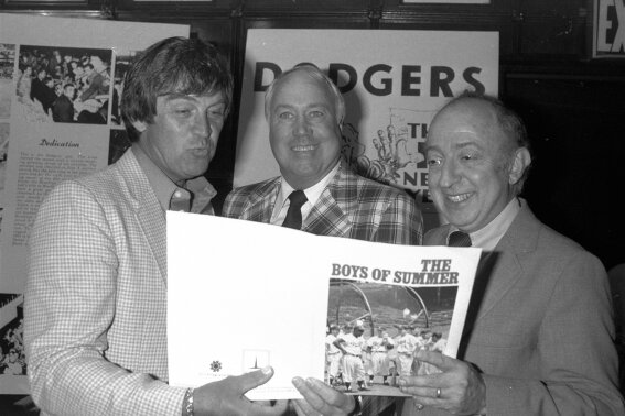 FILE - In this June 24, 1982, file photo, author Roger Kahn, right, joins former Brooklyn Dodger outfielder Duke Snider, center, and former Dodger pitcher, Clem Labine, at the start of production on the television film based on Kahn's best selling book, "The Boys of Summer," in New York. Kahn, the writer who wove memoir and baseball and touched millions of readers through his romantic account of the Brooklyn Dodgers died Thursday, Feb. 6, 2020, at a nursing facility in Mamaroneck, N.Y., according to his son Gordon Kahn. He was 92. (AP Photo/Dave Pickoff, File)
