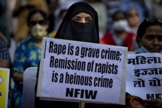 FILE-A Muslim woman holds a placard against remission of sentence by the government to convicts of a gang rape of a Muslim woman in communal violence in 2002 in western Gujarat state, during a protest in New Delhi, India, Aug. 27, 2022. India’s top court Monday cancelled remission of sentence to 11 convicted rapists who had been jailed for life for gang raping a Muslim woman during the country’s deadly 2002 religious riots and asked them to surrender before the authorities within two weeks. (AP Photo/Altaf Qadri, File)