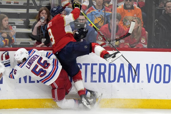Florida Panthers center Sam Bennett (9) slams New York Rangers defenseman Ryan Lindgren (55) into the boards in the third period of Game 3 during the Eastern Conference finals of the NHL hockey Stanley Cup playoffs, Sunday, May 26, 2024, in Sunrise, Fla. (AP Photo/Wilfredo Lee)