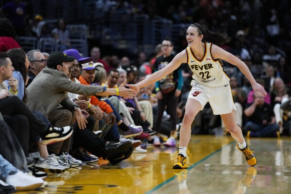 Indiana Fever guard Caitlin Clark (22) greets Ashton Kutcher after making a 3-pointer during the second half of a WNBA basketball game against the Los Angeles Sparks in Los Angeles, Friday, May 24, 2024. (AP Photo/Ashley Landis)