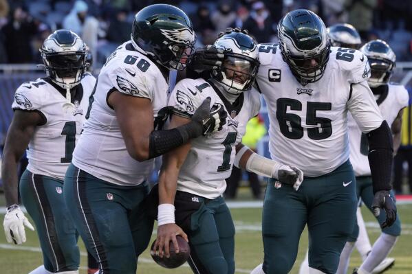 Philadelphia Eagles' Jalen Hurts (1) celebrates with Lane Johnson (65) and Jordan Mailata (68) after running for a two-point conversion during the second half of an NFL football game against the Chicago Bears, Sunday, Dec. 18, 2022, in Chicago. (AP Photo/Charles Rex Arbogast)