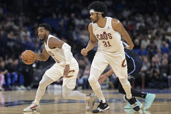 FILE - Cleveland Cavaliers guard Donovan Mitchell, left, drives to the basket as center Jarrett Allen (31) looks on during the first half of an NBA basketball game against the Orlando Magic, Monday, Jan. 22, 2024, in Orlando, Fla. Game 1 of the Cavaliers playoffs series against the Orlando Magic starts Saturday, April 20. (AP Photo/Phelan M. Ebenhack, File)