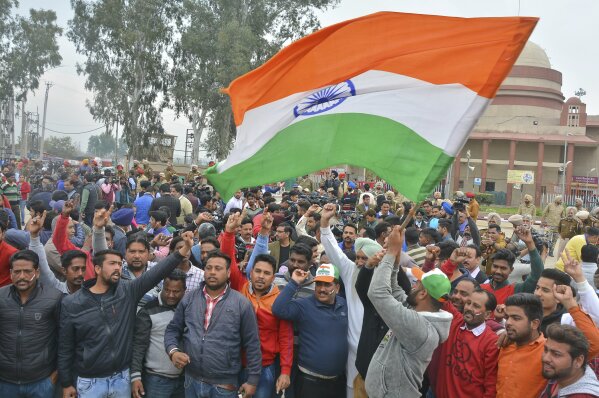 
              An Indian waves national flag as others shout slogans while they wait to welcome Indian pilot at India Pakistan border at Wagah, 28 kilometers (17.5 miles) from Amritsar, India, Friday, March 1, 2019. Pakistan is preparing to hand over a captured Indian pilot as shelling continued for a third night across the disputed Kashmir border even as the two nuclear-armed neighbors seek to defuse the most serious confrontation in two decades. (AP Photo/Prabhjot Gill)
            