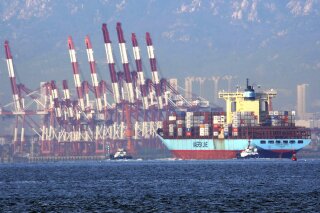 
              In this Oct. 8, 2018, photo, tugboats move a container ship to the dockyard of a seaport in Qingdao in eastern China's Shandong province. Customs data on Friday, Oct. 12, 2018 showed China's trade surplus with the United States widened to a record $34.1 billion September as exports to the U.S. market rose by 13 percent over a year earlier despite a worsening tariff war. (Chinatopix via AP)
            