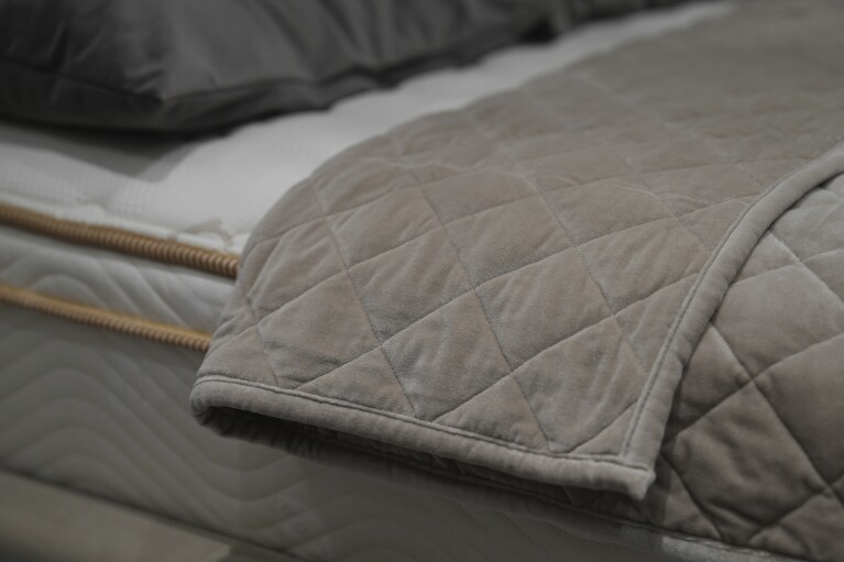 Weighted blankets on display in a Saatva mattress showroom in New York, Dec. 4, 2024. (AP Photo/Mary Conlon)