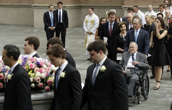 
              Former President George H.W. Bush and George W. Bush, followed by former first lady Laura Bush follow as pallbearers carry the casket of former first lady Barbara Bush after a funeral service at St. Martin's Episcopal Church, Saturday, April 21, 2018, in Houston. (AP Photo/Evan Vucci)
            