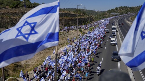 Thousands of Israelis march along a highway towards Jerusalem in protest of plans by Prime Minister Benjamin Netanyahu's government to overhaul the judicial system, near Abu Gosh, Israel, Saturday, July 22, 2023. The 70-kilometer (roughly 45-mile) march from Tel Aviv to Jerusalem is growing as Netanyahu vows to forge ahead on the controversial overhaul. Protest organizers planned to camp overnight outside Israel's parliament on Saturday. (AP Photo/Ohad Zwigenberg)