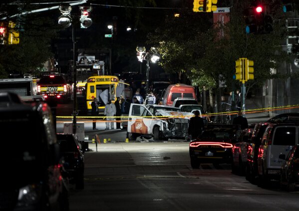Authorities stand near a damaged Home Depot truck after a motorist drove onto a bike path near the World Trade Center memorial, striking and killing several people Tuesday, Oct. 31, 2017, in New York. (AP Photo/Craig Ruttle)