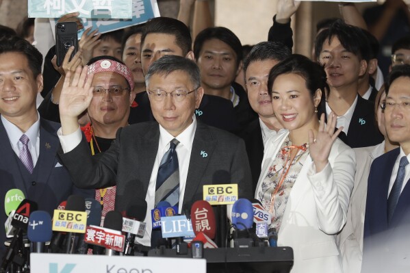 Taiwan's Taiwan People's Party (TPP) presidential candidate Ko Wen-je, front left, and his vice president candidate Cynthia Wu Hsin-ying wave to the media outside of Central Election Commission in Taipei, Taiwan, Friday, Nov. 24, 2023. (AP Photo/ Chiang Ying-ying)