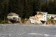 A home hangs over the edge of an eroded riverbank after part of the neighboring house fell into the Mendenhall River in Juneau, Alaska, on Sunday, Aug. 6, 2023. The city of Juneau says the Mendenhall River flooded on Saturday because of a major release from Suicide Basin above Alaska's capital city, and at least two buildings were destroyed. (Mark Sabbatini/Juneau Empire via AP)