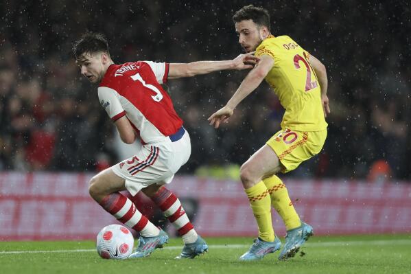 Arsenal's Kieran Tierney, left, and Liverpool's Diogo Jota compete for the ball during the English Premier League soccer match between Arsenal and Liverpool at Emirates Stadium in London, Wednesday, March 16, 2022. (AP Photo/Ian Walton)