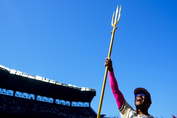 Seattle Mariners' Julio Rodríguez lifts a trident after a postgame interview to celebrate a win over the Oakland Athletics in a baseball game Sunday, May 12, 2024, in Seattle. (AP Photo/Lindsey Wasson)