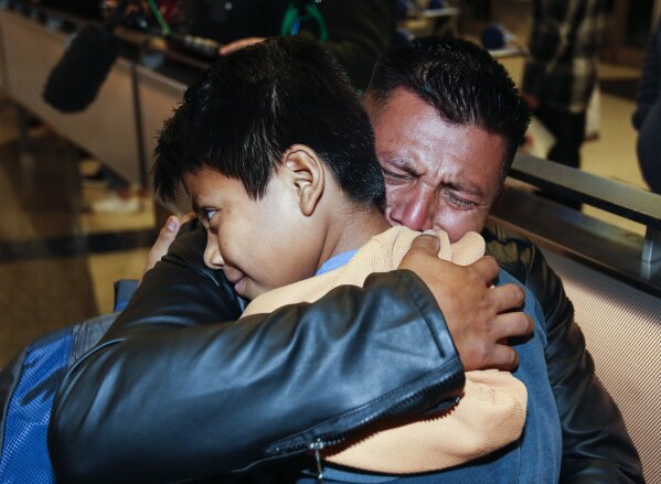 David Xol-Cholom, of Guatemala hugs his son Byron at Los Angeles International Airport as they reunite after being separated about one and half year ago during the Trump administration's wide-scale separation of immigrant families, Wednesday, Jan. 22, 2020, in Los Angeles. (AP Photo/Ringo H.W. Chiu)