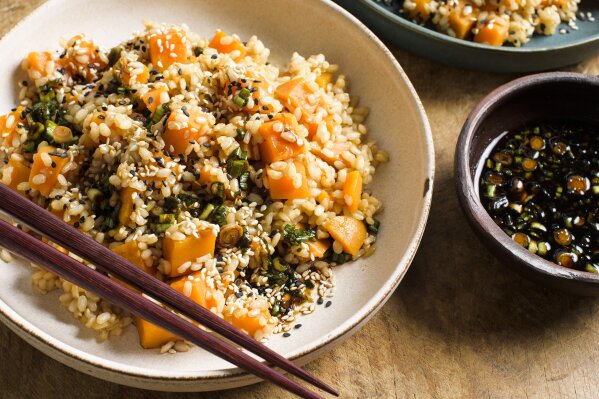 This image released by Milk Street shows a recipe for sweet potato brown rice with soy and scallions. (Milk Street via AP)