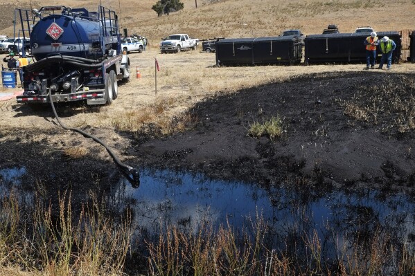 FILE - Workers monitor an underground oil pipe break up a hill from Refugio State Beach, north of Goleta, Calif., on May 20, 2015. ExxonMobil lost a court bid on Wednesday, Sept. 27, 2023, to truck millions of gallons of crude oil through central California, a crucial part of its efforts to restart offshore oil wells that were shut in 2015 after the pipeline leak caused the worst coastal spill in 25 years. (AP Photo/Michael A. Mariant, File)