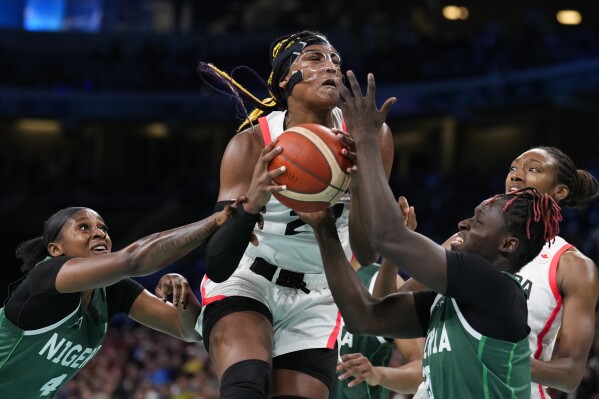 Aaliyah Edwards (24), of Canada, shoots between Elizabeth Balogun (4) and Murjanatu Musa (20), of Nigeria, in a women's basketball game at the 2024 Summer Olympics, Sunday, Aug. 4, 2024, in Villeneuve-d'Ascq, France. (AP Photo/Mark J. Terrill)