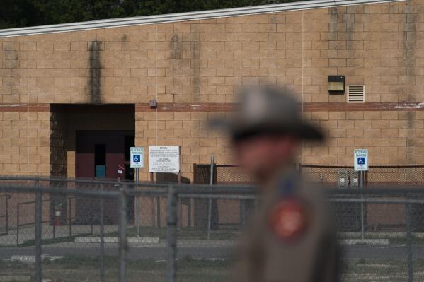 A back door at Robb Elementary School, where a gunman entered through to get into a classroom in last week's shooting, is seen in the distance in Uvalde, Texas, Monday, May 30, 2022. (AP Photo/Jae C. Hong)