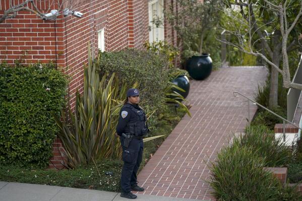 A police officer stands outside the home of House Speaker Nancy Pelosi and her husband Paul Pelosi in San Francisco, Friday, Oct. 28, 2022. Paul Pelosi, was attacked and severely beaten by an assailant with a hammer who broke into their San Francisco home early Friday, according to people familiar with the investigation. (AP Photo/Godofredo A. Vásquez)