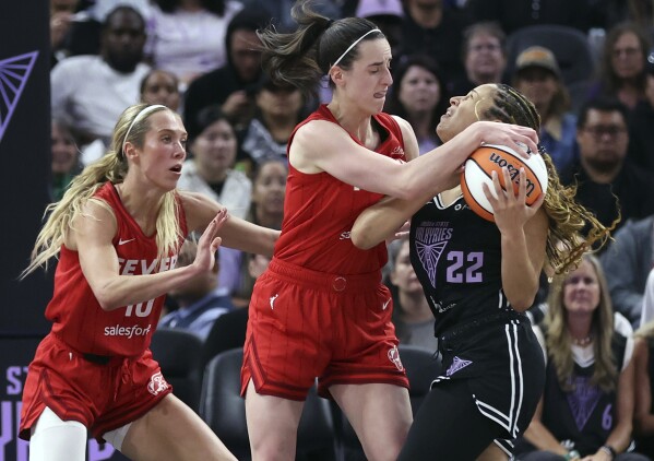 Golden State Valkyries' Veronica Burton (22) is fouled by Indiana Fever's Caitlin Clark, center, as Fever's Lexie Hall, left, looks on in thee second quarter of a WNBA game in San Francisco, Thursday, June 19, 2025. (Scott Strazzante/San Francisco Chronicle via AP)