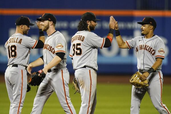 San Francisco Giants' Tommy La Stella (18) and Brandon Crawford (35) celebrate with teammates after a baseball game against the New York Mets Wednesday, Aug. 25, 2021, in New York. The Giants won 3-2. (AP Photo/Frank Franklin II)
