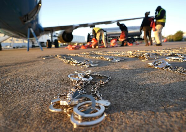 
              In this Friday, Nov. 16, 2018, photo, restraints lie on the tarmac as personal belongings of immigrants who entered the United States illegally are loaded onto a plane for a deportation flight to El Salvador by U.S. Immigration and Customs Enforcement in Houston. An obscure division of U.S. Immigration and Customs Enforcement operates hundreds of flights each year to remove immigrants. (AP Photo/David J. Phillip)
            