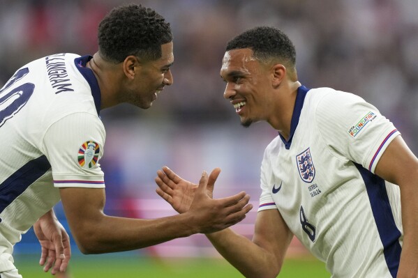 England's Jude Bellingham, left, celebrates with England's Trent Alexander-Arnold after scoring the opening goal during a Group C match between Serbia and England at the Euro 2024 soccer tournament in Gelsenkirchen, Germany, Sunday, June 16, 2024. (AP Photo/Martin Meissner)