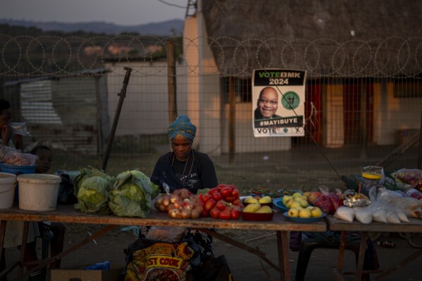 Seorang wanita menjual buah-buahan dan sayuran di dekat TPS tempat mantan Presiden Afrika Selatan Jacob Zuma diperkirakan akan memberikan suaranya, di KwaZulu-Natal, Afrika Selatan, Afrika Selatan, Selasa, 28 Mei 2024, menjelang jadwal pemilihan umum 2024 untuk 29 Mei. (Foto AP /Emilio Morenatti)