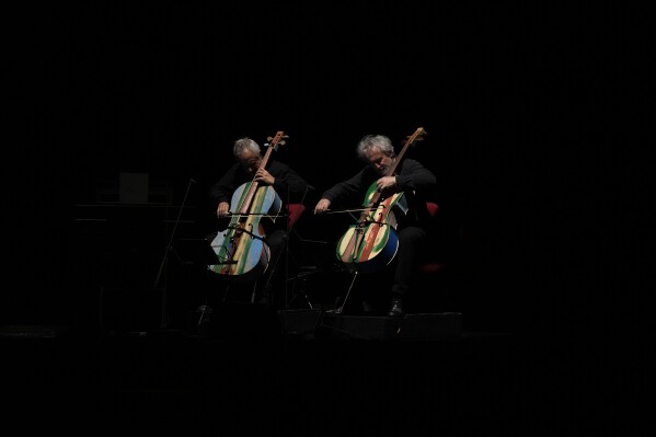 Members of the 'Sea Orchestra' play with cellos made from the wood of wrecked immigrants' boats in Milan, Italy, Saturday, Feb. 10, 2024. Inmates at Milan's maximum security prison Opera took the wood of wrecked boats sailed by migrants across the Sicily Channel to craft the musical instruments that the 'Sea Orchestra' used during their debut at La Scala Opera House in Milan on Monday, Feb. 12, 2024. The violins, violas and cellos played by the Orchestra of the Sea in its debut performance Monday at Milan's famed Teatro all Scala carry with them tales of hardship. (AP Photo/Antonio Calanni)