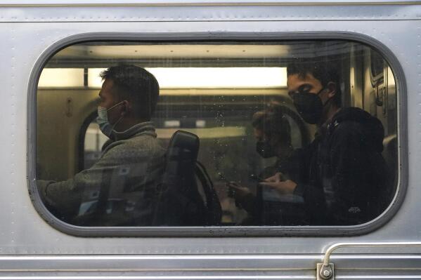 People wear face masks as they sit in a Metra train at the Metra Arlington Heights station Thursday, Sept. 15, 2022, in Arlington Heights, Ill. President Joe Biden said Thursday a tentative railway labor agreement has been reached, averting a potentially devastating strike before the pivotal midterm elections. (AP Photo/Nam Y. Huh)