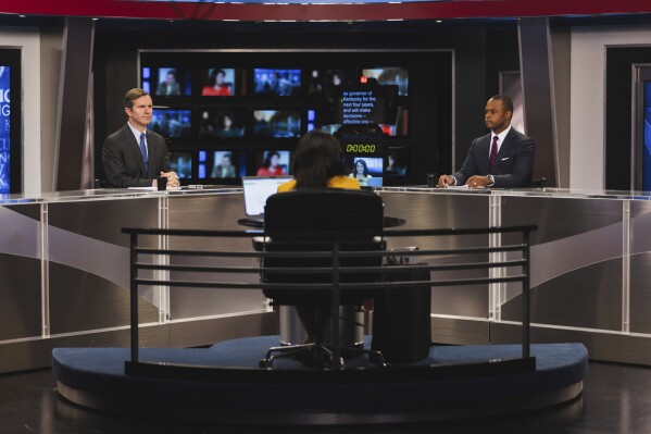 Moderator Renee Shaw, center, talks with Kentucky gubernatorial candidates Democratic Gov. Andy Beshear, left, and Republican Attorney General Daniel Cameron during a debate at KET Network Center in Lexington, Ky., Monday, Oct. 23, 2023. (Kentucky Educational Television via AP, Pool)