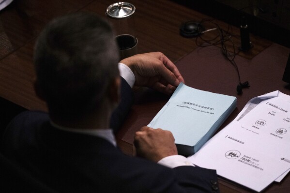 FILE - A lawmaker holds a copy of the proposed Safeguarding National Security Bill at the Legislative Council in Hong Kong, March 19, 2024. The United States sees Hong Kong's new national security law as a tool to potentially silence dissent both at home and abroad, but has tread carefully so far in responding, a disappointment to those fighting for democracy and freedoms in the Chinese territory. (AP Photo/Louise Delmotte, File)