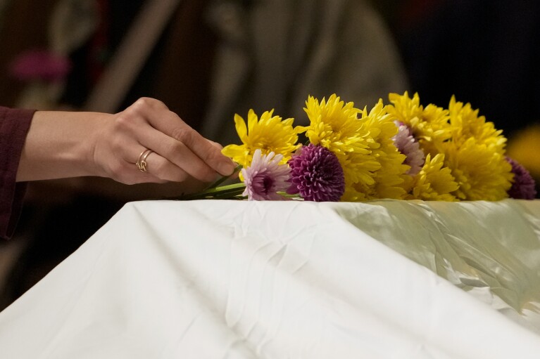 Buddhist faith leaders and community members offer flowers at an altar in memory of those who lost their lives due to anti-Asian hate, Saturday, March 16, 2024, in Antioch, Calif. The event aimed to use karmic cleansing through chants, prayer and testimony to heal racial trauma caused by anti-Chinese discrimination in Antioch in the 1870s. (AP Photo/Godofredo A. Vasquez)