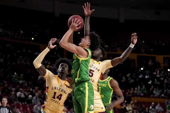 FILE - Oregon guard Will Richardson, center, shoots as Arizona State center Enoch Boakye (14) looks on during the first half of an NCAA college basketball game, Thursday, Feb. 17, 2022, in Tempe, Ariz. The Ducks return three starters, including guard Will Richardson who led the team in scoring and assists. (AP Photo/Matt York, File)