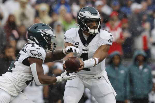 Philadelphia Eagles quarterback Jalen Hurts, right, hands off to running back Kenneth Gainwell, left, in the first half of an NFL football game against the New England Patriots, Sunday, Sept. 10, 2023, in Foxborough, Mass. (AP Photo/Michael Dwyer)