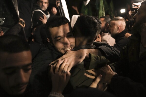 A man smiles as he is welcomed after being released from prison by Israel, in the West Bank town of Ramallah, early Thursday, Nov. 30, 2023. International mediators on Wednesday worked to extend the truce in Gaza, encouraging Hamas militants to keep freeing hostages in exchange for the release of Palestinian prisoners and further relief from Israel's air and ground offensive. (AP Photo/Nasser Nasser)