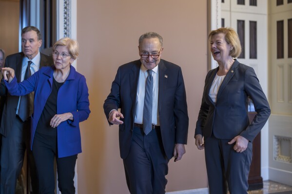 Senate Majority Leader Chuck Schumer, D-N.Y., center, is joined by, from left, Sen. Mark Warner, D-Va., Sen. Elizabeth Warren, D-Mass., and Sen. Tammy Baldwin, D-Wis., right, as they emerge from Democratic Caucus leadership elections, at the Capitol in Washington, Tuesday, Dec. 3, 2024. (AP Photo/J. Scott Applewhite)