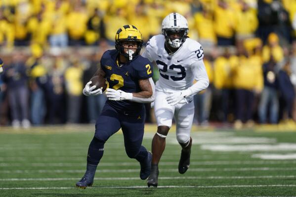 Michigan running back Blake Corum (2) runs the ball as Penn State linebacker Curtis Jacobs (23) chases in the first half of an NCAA college football game in Ann Arbor, Mich., Saturday, Oct. 15, 2022. (AP Photo/Paul Sancya)