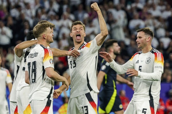 Germany's Thomas Mueller, center, celebrates during the Group A match between Germany and Scotland at the Euro 2024 soccer tournament in Munich, Germany, Friday, June 14, 2024. (Christian Charisius/dpa via AP)