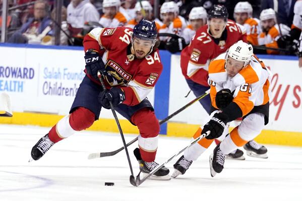 Florida Panthers left wing Ryan Lomberg (94) skates with the puck as Philadelphia Flyers defenseman Justin Braun (61) defends during the second period of an NHL hockey game, Wednesday, Nov. 24, 2021, in Sunrise, Fla. (AP Photo/Lynne Sladky)