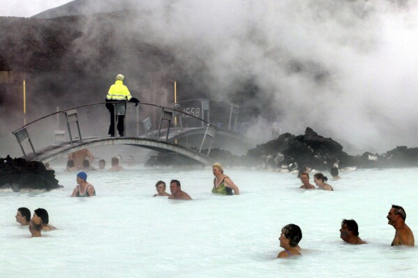 FILE-Bathers enjoy the warm water of the Blue Lagoon on Iceland on Sept.5, 2003. The geothermal spa Blue Lagoon has temporarily closed after a series of earthquakes have put Iceland's southwestern corner on volcanic alert, reaching a state of panic on Thursday when a magnitude 5.0 earthquake occurred just after midnight. (AP Photo/Frank Augstein, File)