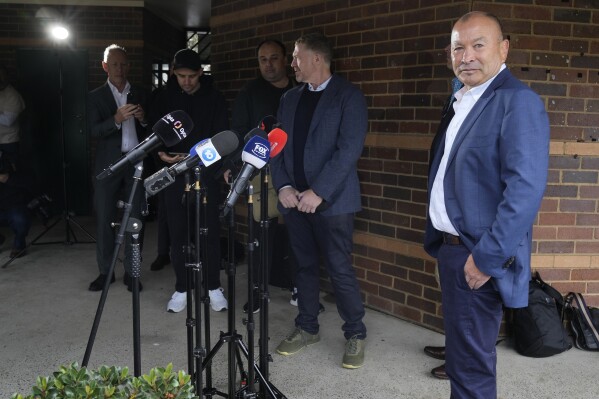 Australian Rugby's head coach Eddie Jones, right, prepares to speak to media in Sydney, Tuesday, Oct. 17, 2023. Wallabies head coach, Jones, says he is "committed to Australia" amid numerous reports that he is planning to quit and take up the Japan coaching job for a second time. (AP Photo/Rick Rycroft)