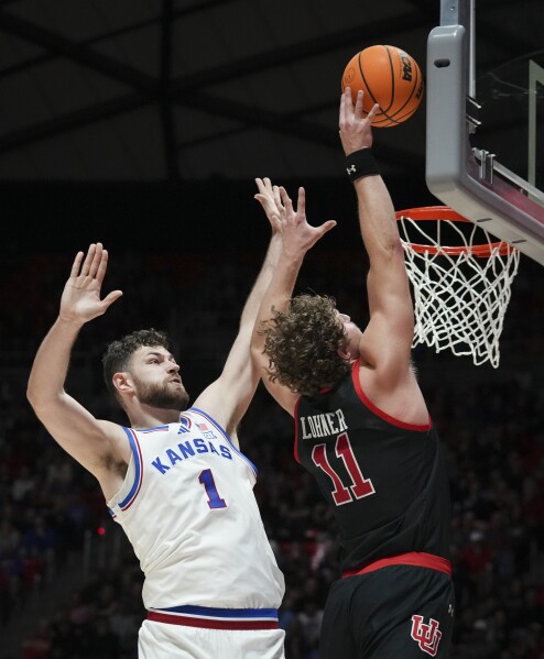 Utah forward Caleb Lohner (11) shoots as Kansas center Hunter Dickinson (1) blocks during the second half of an NCAA college basketball game, Saturday, Feb. 15, 2025, in Salt Lake City. (AP Photo/Bethany Baker)