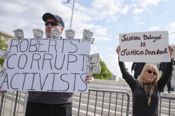Demonstraters stand outside the Supreme Court as the justices prepare to hear arguments over whether Donald Trump is immune from prosecution in a case charging him with plotting to overturn the results of the 2020 presidential election, on Capitol Hill Thursday, April 25, 2024, in Washington. (AP Photo/Mariam Zuhaib)