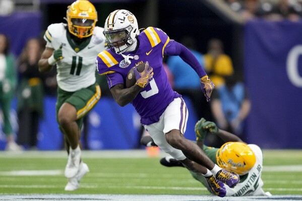 LSU wide receiver Chris Hilton Jr., center, gets past a tackle by Baylor cornerback LeVar Thornton Jr., bottom right, for a gain during the first half of the Texas Bowl NCAA college football game Tuesday, Dec. 31, 2024, in Houston. (Brett Coomer/Houston Chronicle via AP)