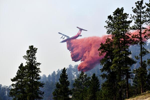 FILE - An aircraft drops fire retardant to slow the spread of the Richard Spring fire, east of Lame Deer, Mont., on Aug. 11, 2021. A legal dispute in Montana could drastically curb the government’s use of aerial fire retardant to combat wildfires. Environmentalists have sued the U.S. Forest Service over waterways being polluted with the potentially toxic red slurry that’s dropped from aircraft. Forest Service officials have acknowledged more than 200 cases of retardant landing in water. (AP Photo/Matthew Brown, File)